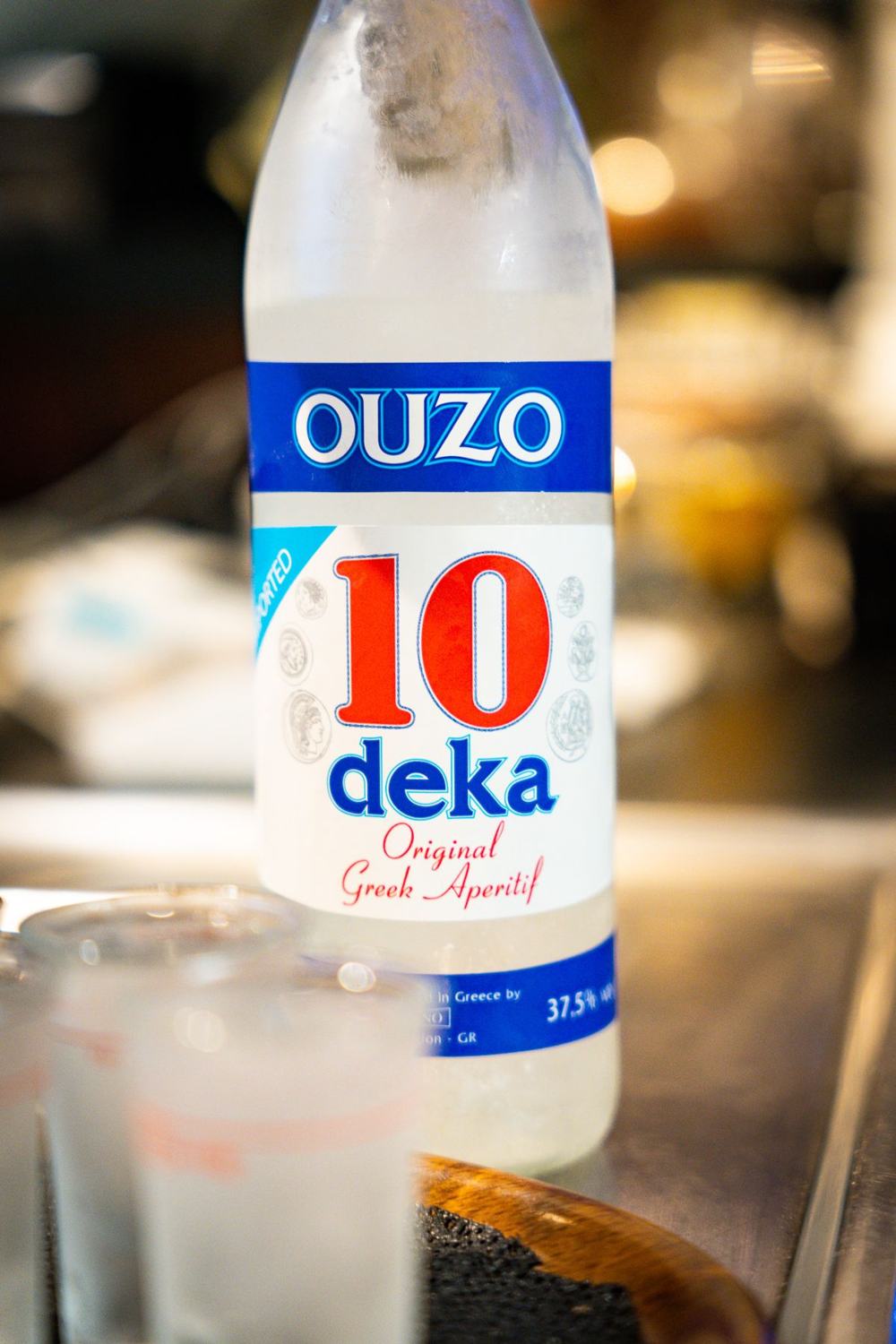 Ouzo-Flasche und Gläser an der Theke